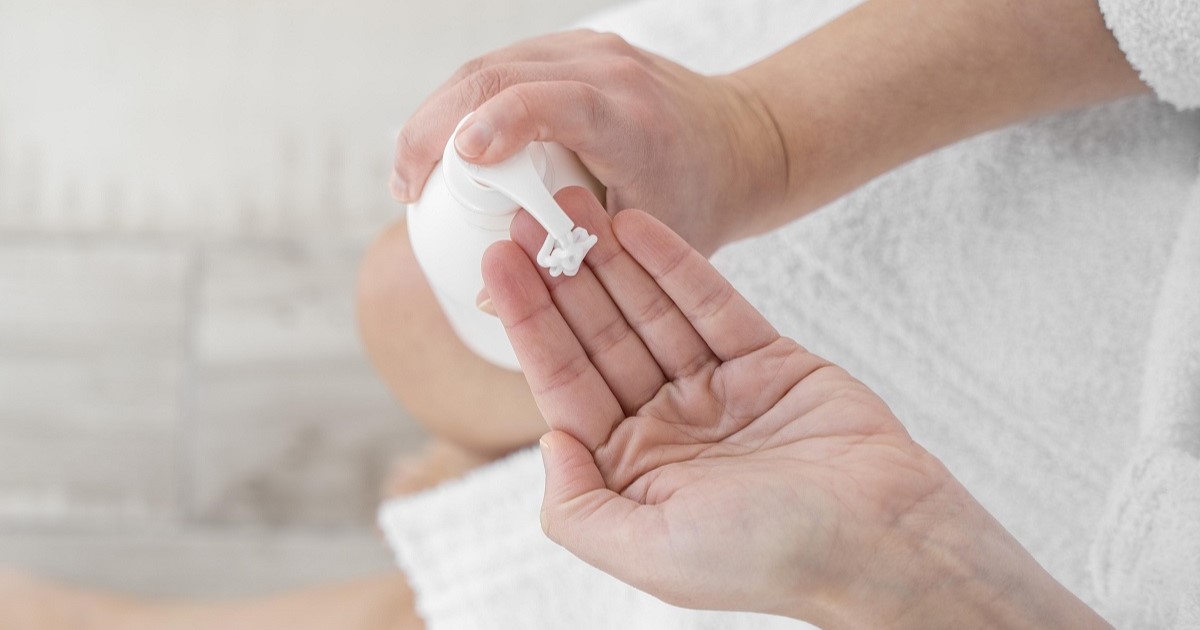 persona se está echando crema en una mano. Posible enfermedad dermatológica.