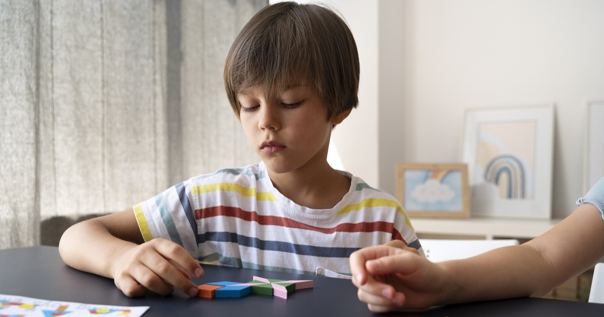 niño haciendo un rompecabezas concentrado. ejemplo de síndrome de asperger