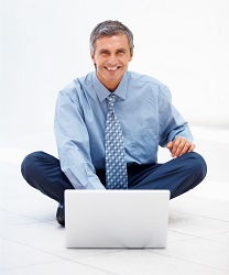 Un hombre con un ordenador que podría llegar a padecer riesgos Psicosociales