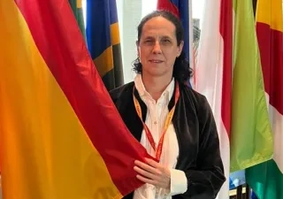 Ana Peláez sosteniendo la bandera de España al lado del resto de banderas mundiales