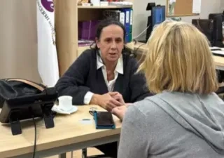 vicepresidenta de CERMI Mujeres hablando en una mesa junto a una señora de espaldas.